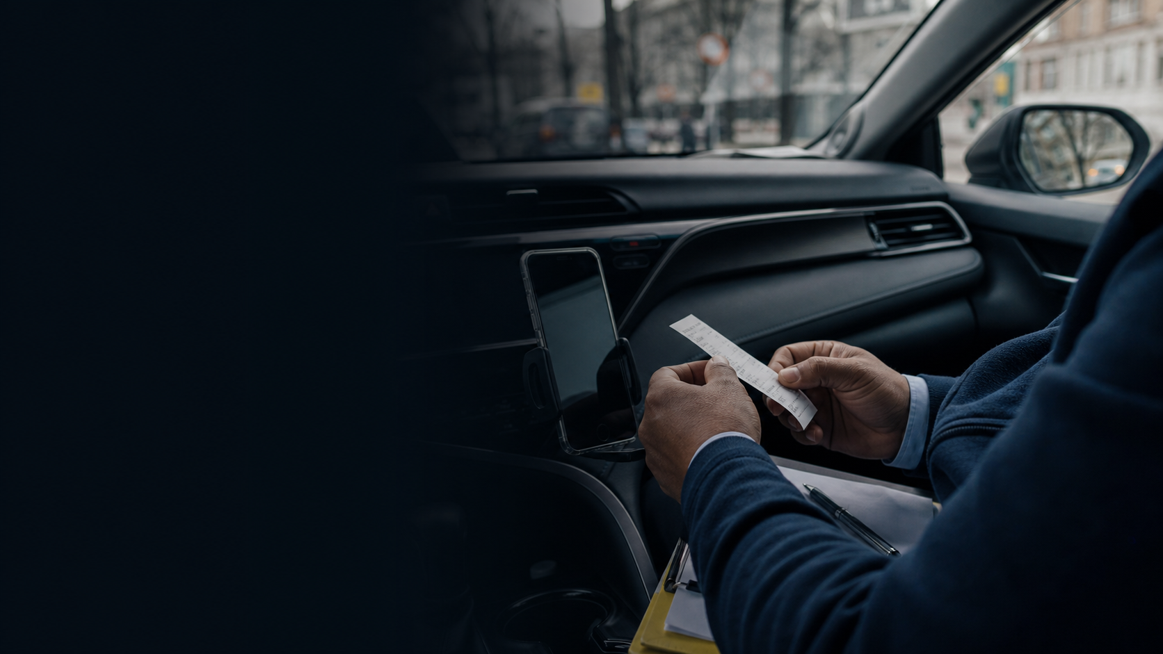 Chauffeur die na een rit een bon controleert in zijn geparkeerde auto